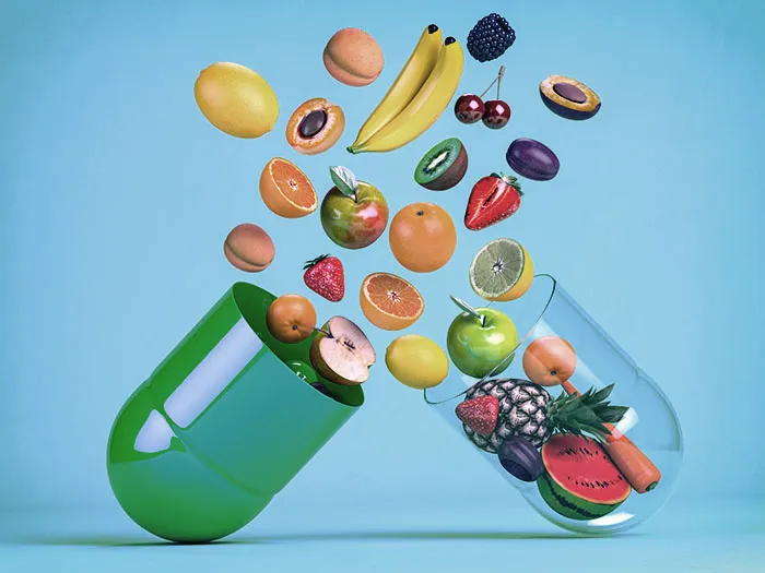 Obst und Gemüse als Inhalt einer Kapsel – symbolische Darstellung von Nahrungsergänzungsmitteln auf natürlicher Basis
