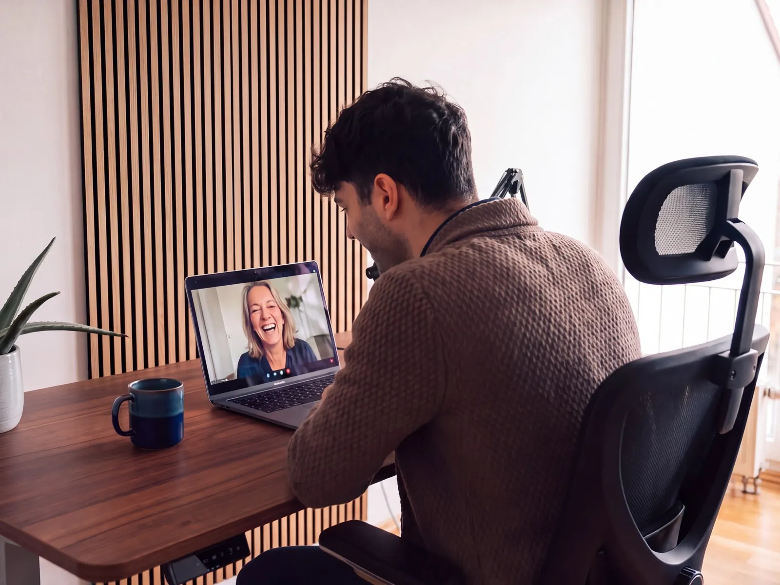Fabio Arcucci am Schreibtisch im Videocall mit einer lachenden Kundin