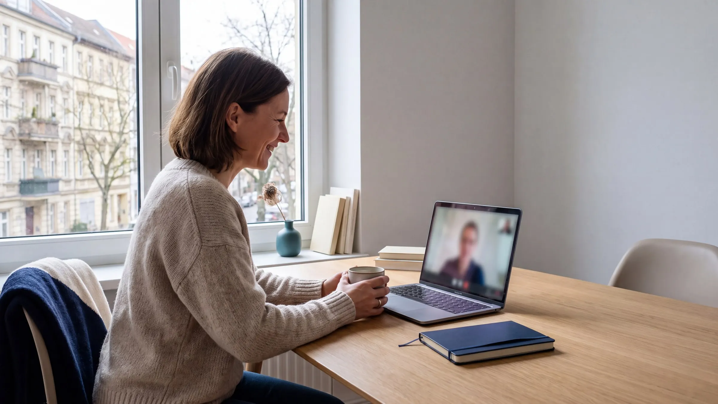 Mitarbeiterin sitzt am Schreibtisch im Videocall am Laptop